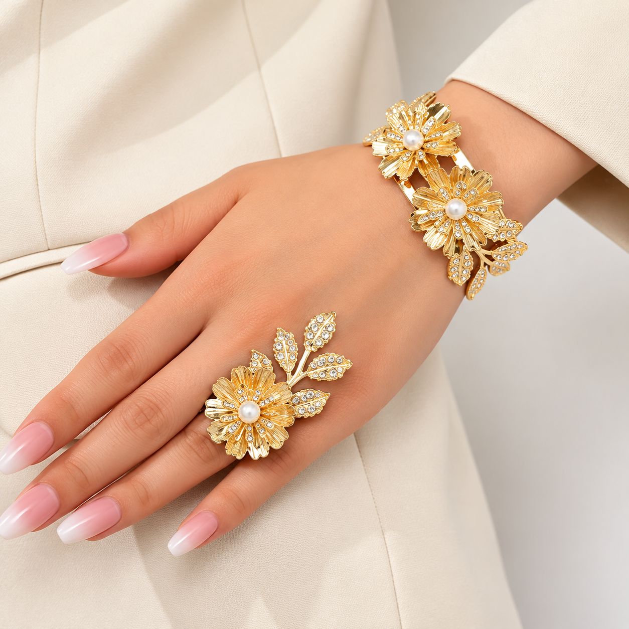 Conjunto de pulsera y anillo dorados con flores y perlas