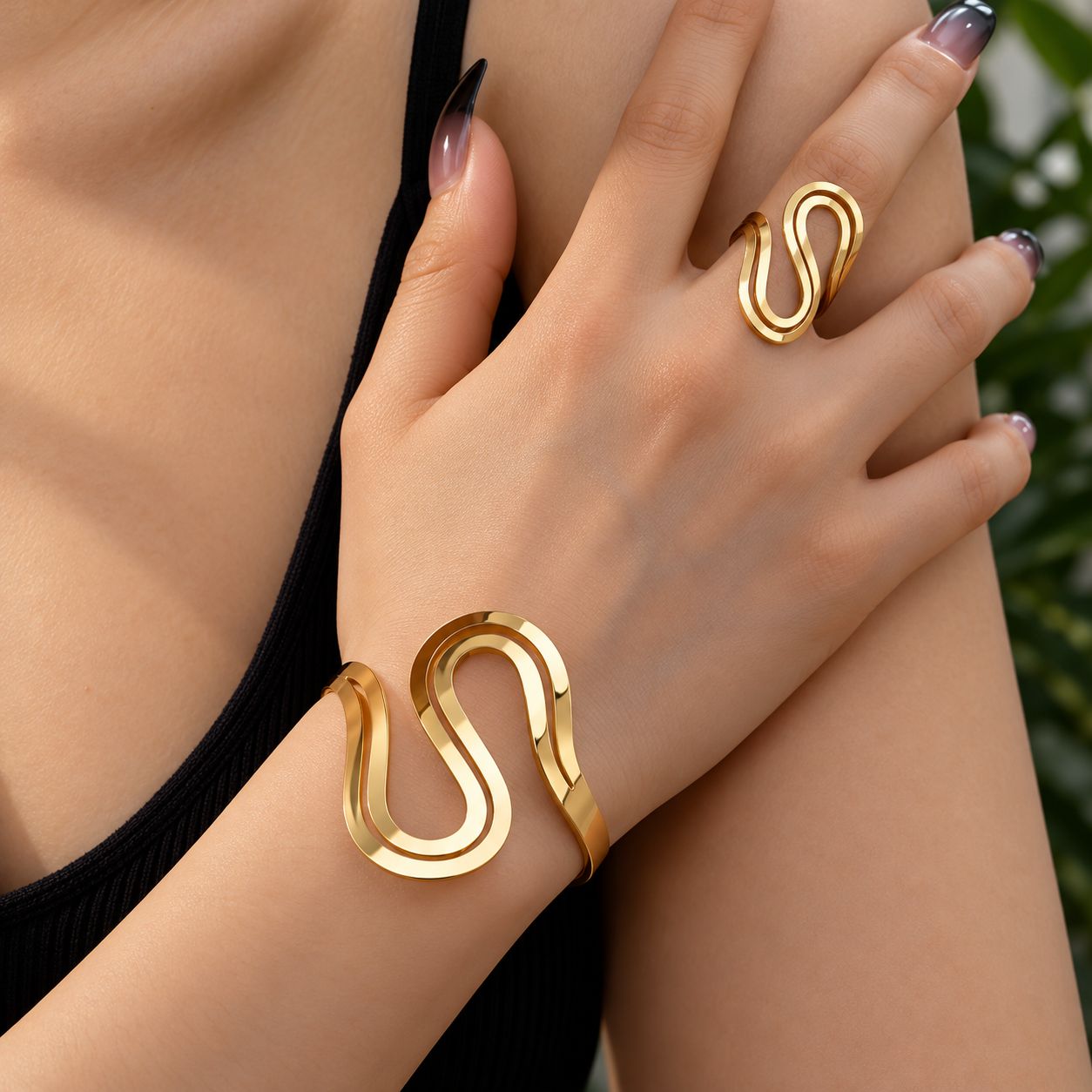 Conjunto de pulsera y anillo dorados con diseño ondulado