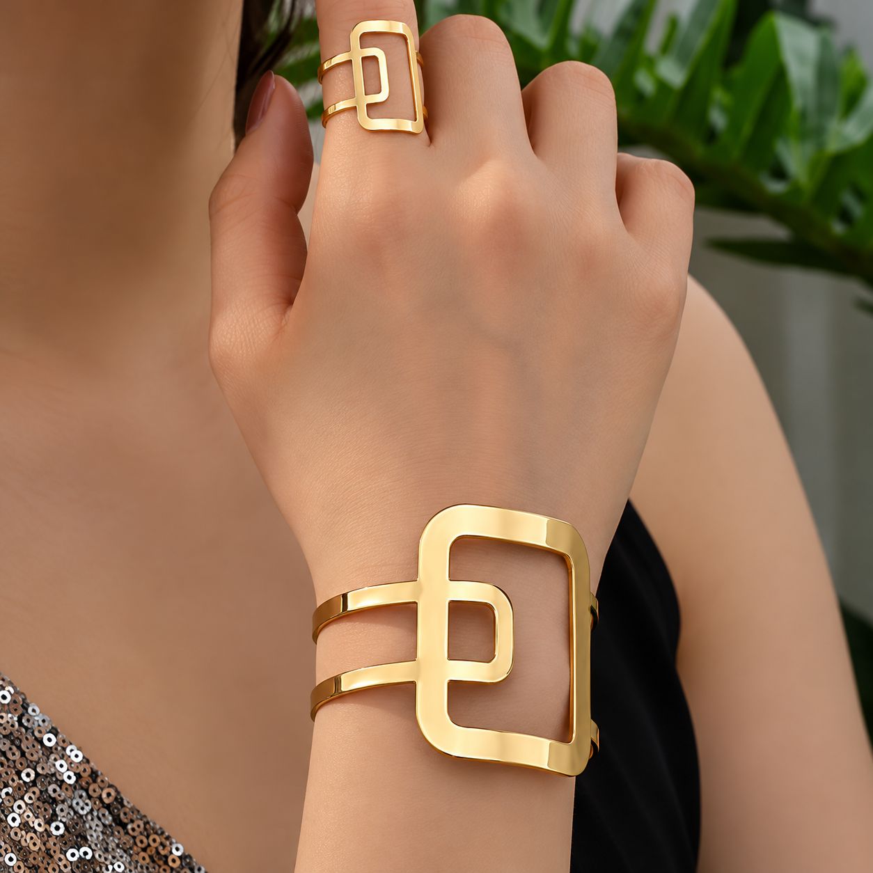 Conjunto de pulsera y anillo dorados con diseño geométrico