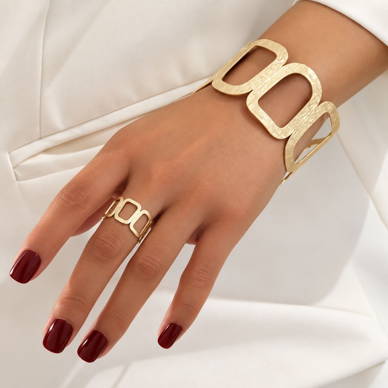 Conjunto de pulsera y anillo dorados con diseño geométrico