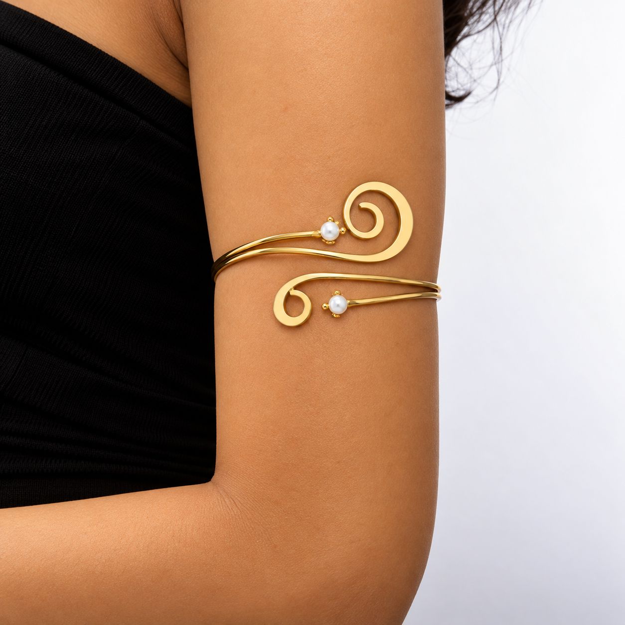 Brazalete dorado con espirales y detalles de perla