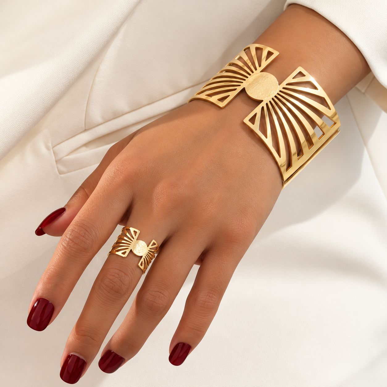 Conjunto de pulsera y anillo dorados con diseño geométrico