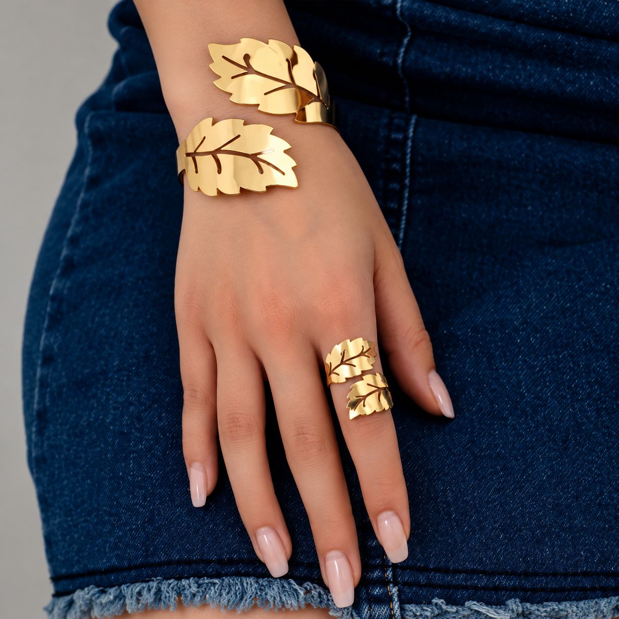 Conjunto de pulsera y anillo dorados con diseño de hojas